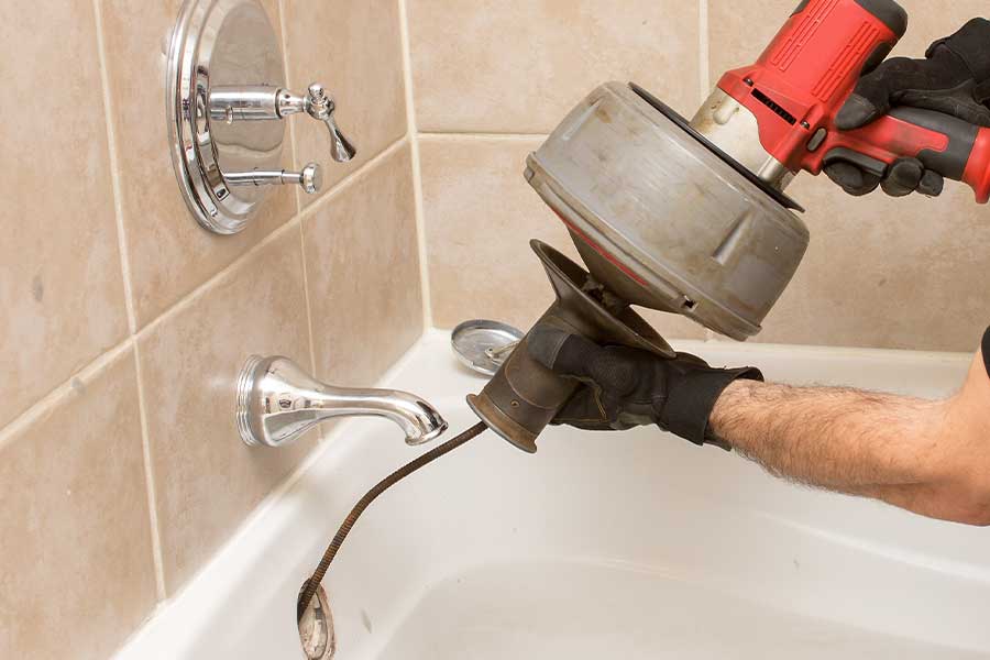 Plumber using tools for drain cleaning